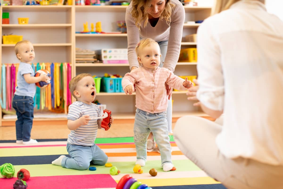 Happy toddlers at Little Antlers Childcare in Helena, MT, sitting together in a colorful daycare classroom
